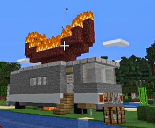 This is a screenshot from one of Wilbur's videos showing a trailer van or RV built in Minecraft. It is grey with a few windows and an iron door. There is a giant hotdog built out of netherrack, a flammable red block, that is is on fire on top of the van. Outside of the van's doors is a set of stairs leading up to it and a shallow pond. Pine trees are in the background behind the van.